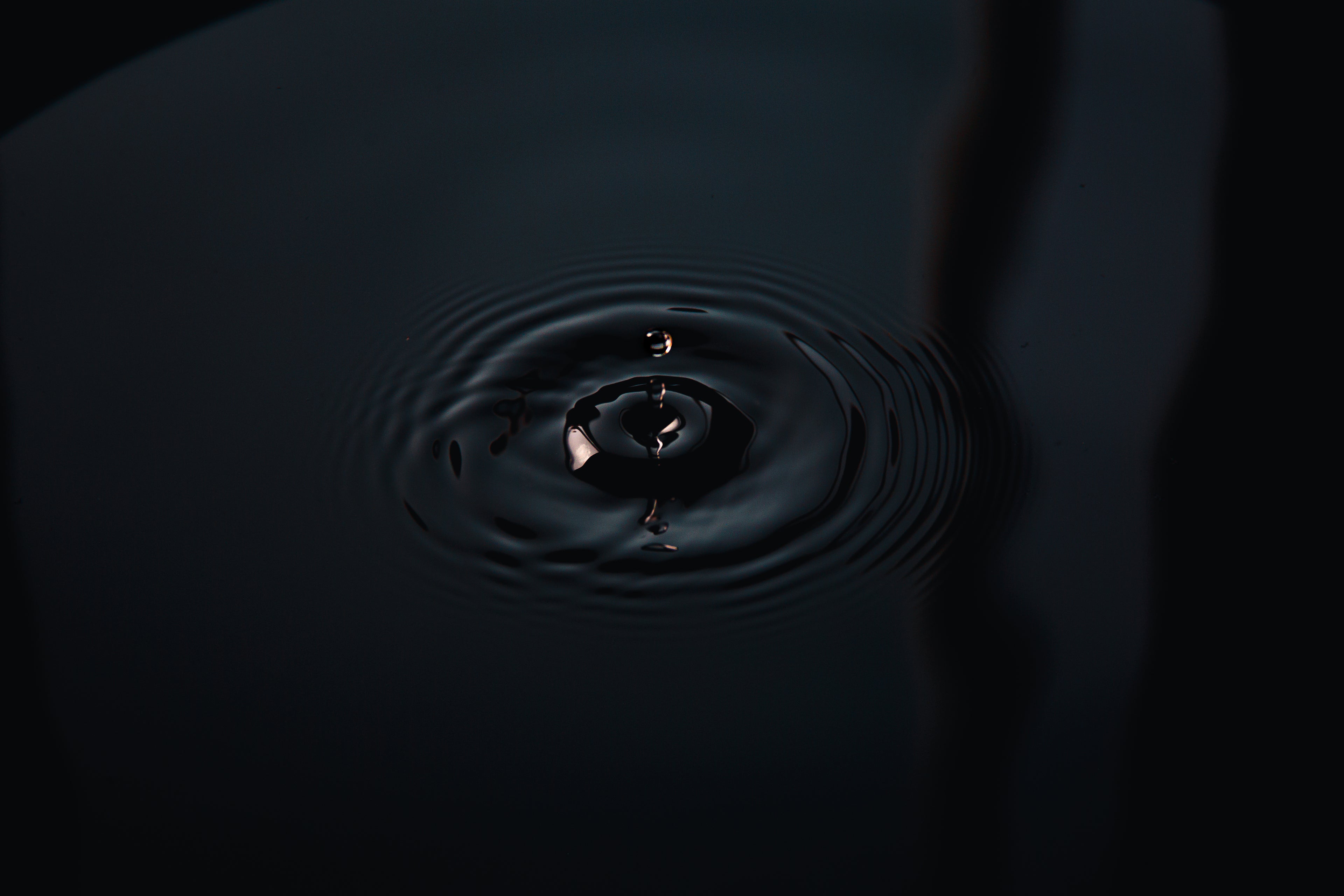 A single droplet of water with ripples coming out.